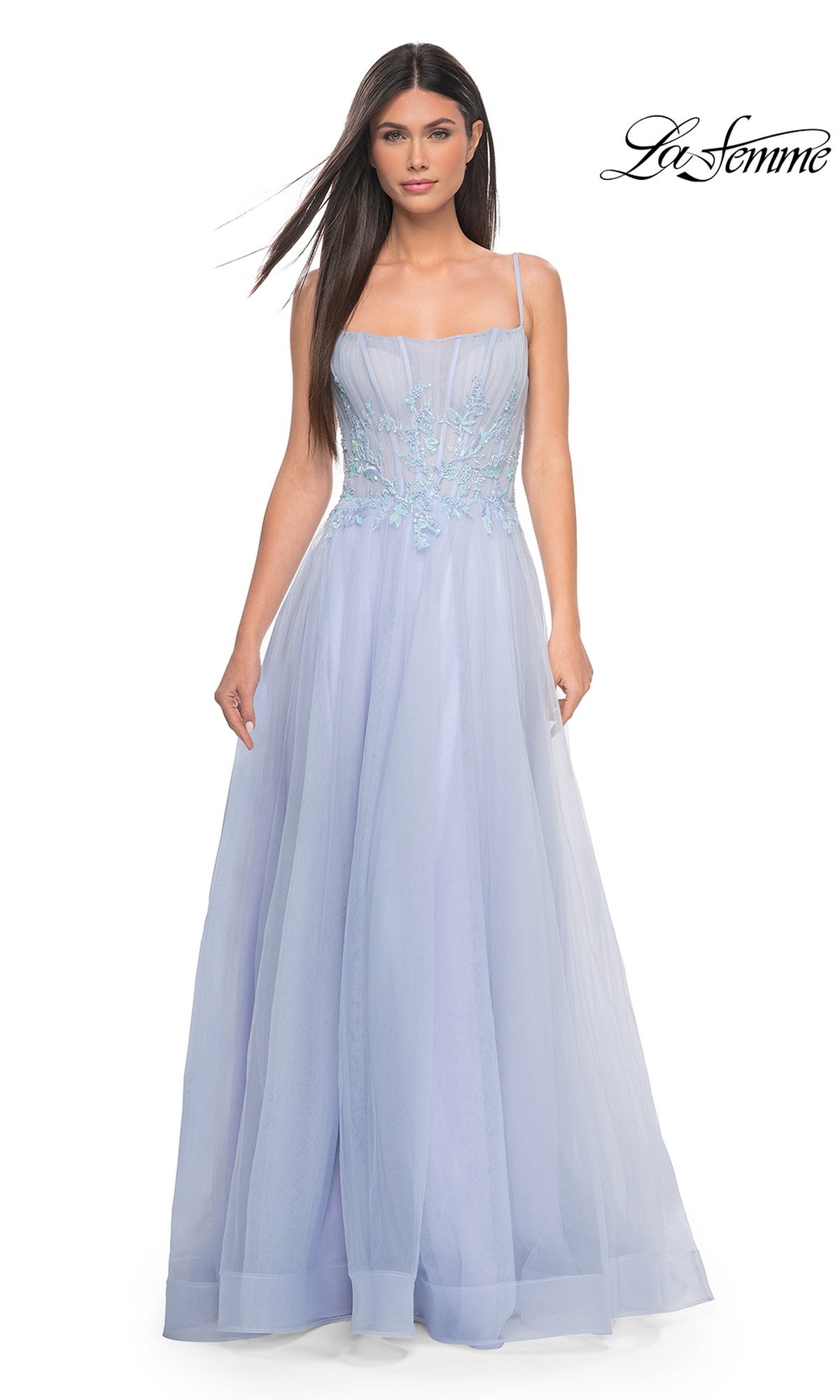 A woman models the La Femme A-Line Long Periwinkle Prom Dress 32293, featuring thin straps, a sheer embroidered bodice, and a floor-length skirt, against a plain white background.